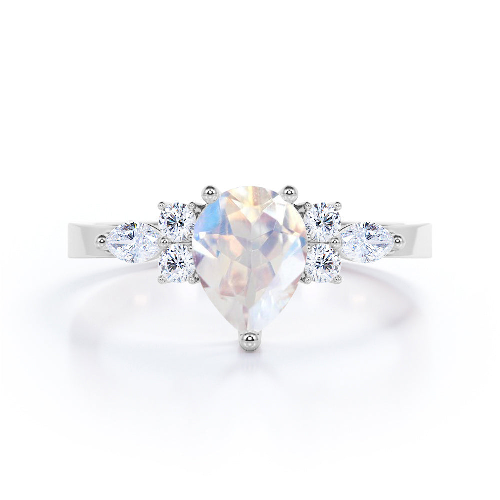 Seven stone 1.25 carat Pear Cut Rainbow Moonstone and diamond triad engagement ring in Black gold