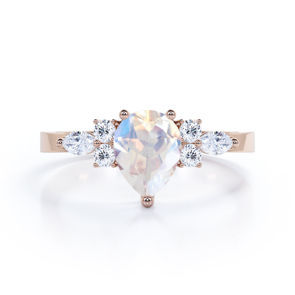 Seven stone 1.25 carat Pear Cut Rainbow Moonstone and diamond triad engagement ring in Black gold