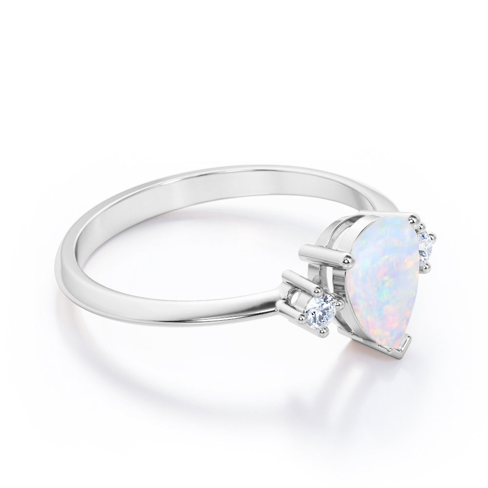 Elegant Three stone 1.10 carat Tear drop shape Ethiopian Opal and diamond pinched shank engagement ring in Black gold