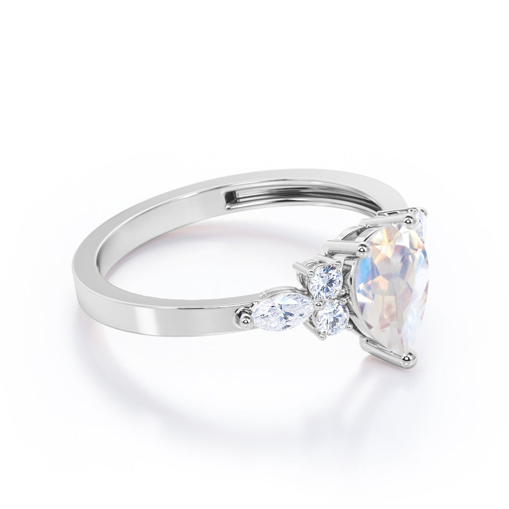 Seven stone 1.25 carat Pear Cut Rainbow Moonstone and diamond triad engagement ring in Black gold
