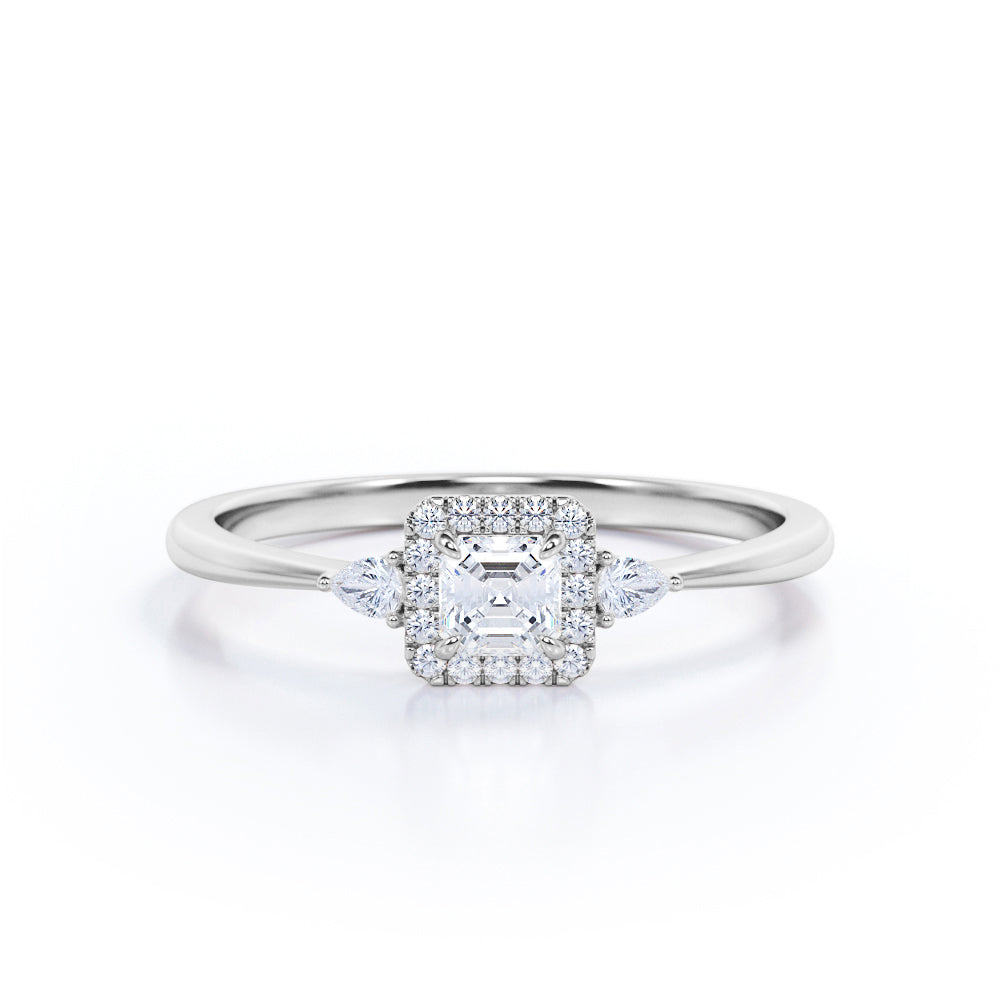 Tapered triple stone 0.7 carat Round cut Moissanite and diamond halo engagement ring in White gold