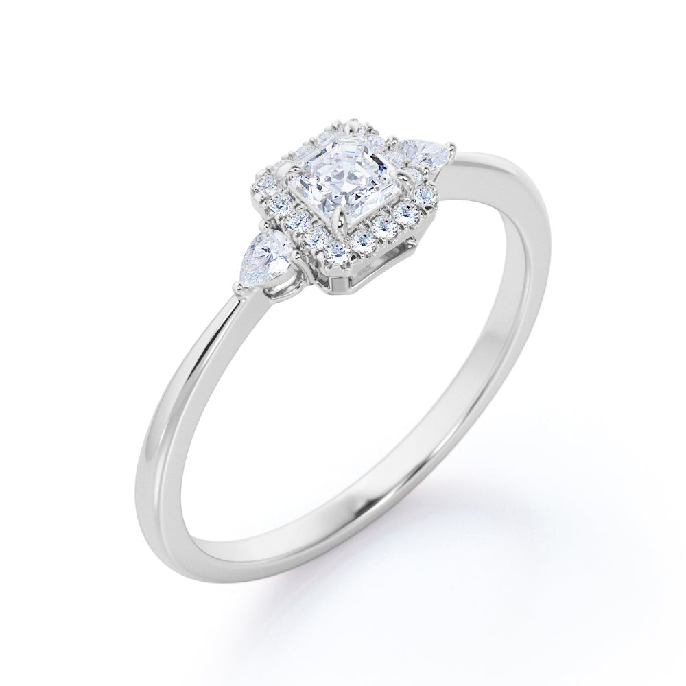 Tapered triple stone 0.7 carat Round cut Moissanite and diamond halo engagement ring in White gold