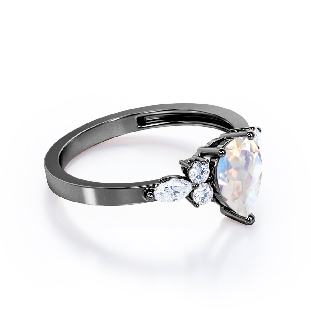 Seven stone 1.25 carat Pear Cut Rainbow Moonstone and diamond triad engagement ring in Black gold