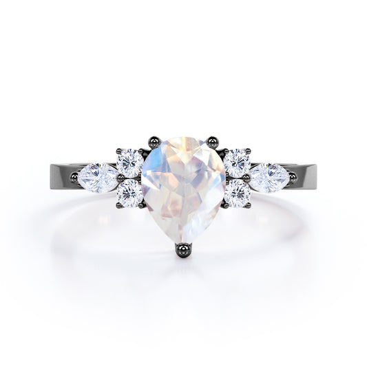 Seven stone 1.25 carat Pear Cut Rainbow Moonstone and diamond triad engagement ring in Black gold