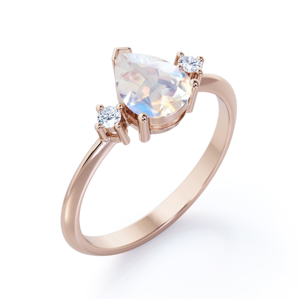 Stylish 1.1 carat Pear Cut Blue Moonstone and diamond trilogy engagement ring in Rose gold