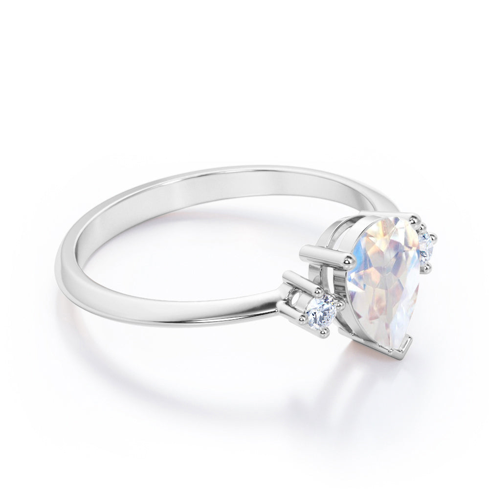 Stylish 1.1 carat Pear Cut Blue Moonstone and diamond trilogy engagement ring in Rose gold