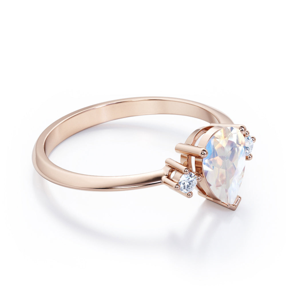 Stylish 1.1 carat Pear Cut Blue Moonstone and diamond trilogy engagement ring in Rose gold